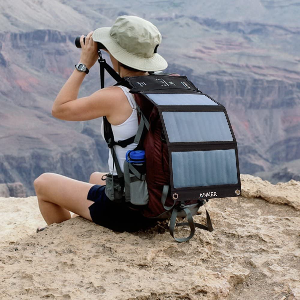 hiker with a foldable solar charger on her backpack