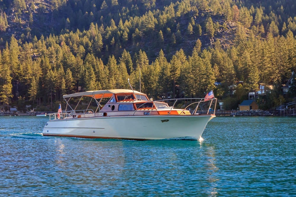 Cruise Tahoe Cruise Tahoe's boat with an American flag on the bow sailing on Lake Tahoe