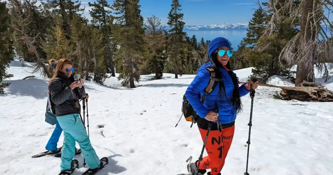 Group of friends on a snowshoe hike above Lake Tahoe with views of the lake in the background